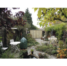 Tuin met een licht houten tuinhuisje, bestrating, witte tuintafel en stoelen, weelderige beplanting en een vijver.