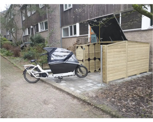 Houten fietsenberging met open deksel en deuren naast een bakfiets bij een woonhuis.