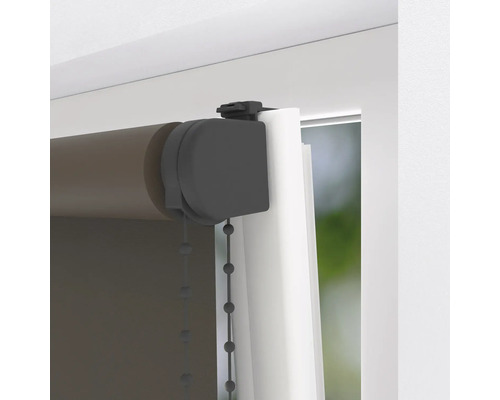 Donkerbruin rolgordijn zonder boren met klembevestiging aan wit kozijn.