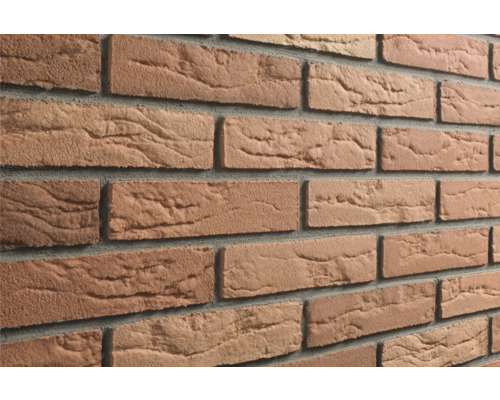 Roodbruine steenstrips met een gestructureerd oppervlak in baksteenlook en grijze voegen.