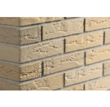 Beige steenstrips met steenlook en ruwe oppervlaktestructuur op een muurhoek.