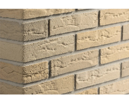 Beige steenstrips met steenlook en ruwe oppervlaktestructuur op een muurhoek.