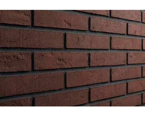 Detailopname van donkerbruine steenstrips in baksteenlook met donkere voegen voor wandafwerking.