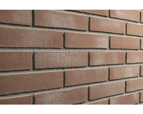 Steenstrips met baksteenlook, roodbruin genuanceerd, ruw oppervlak, met grijze voegen.