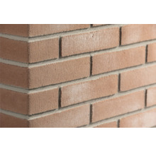 Roodbruine steenstrips met baksteenlook voor de wandafwerking met een ruw oppervlak en grijze voegen.