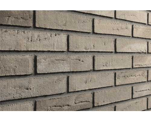 Grijsbruine steenstrips met een gestructureerd oppervlak, verwerkt als een bakstenen muur met donkere voegen.