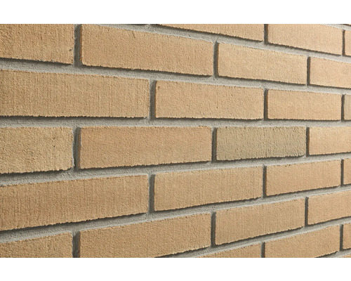 Steenstrips in baksteenlook met een gestructureerd, zanderig oppervlak en voegen.