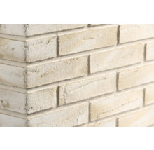 Steenstrips met baksteenlook en een ruw, gestructureerd oppervlak op een muurhoek.