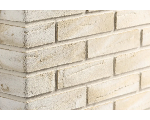 Steenstrips met baksteenlook en een ruw, gestructureerd oppervlak op een muurhoek.