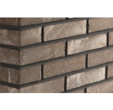 Grijsbruine steenstrips in baksteenlook met een gestructureerd oppervlak op een muurhoek.