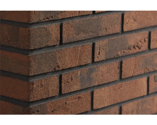 Roodbruine steenstrips in baksteenlook met een gestructureerd oppervlak en donkere voegen op een hoek.