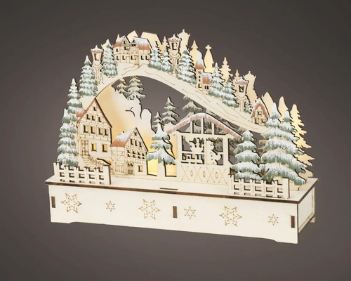 Houten kerstboog met verlicht winterdorp, huisjes en besneeuwde dennenbomen.