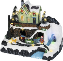 Geanimeerd kerstdorp met een besneeuwde berg, verlicht huis, rijdende trein, figuren und ledverlichting.