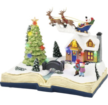 Kerstdecoratie in de vorm van een open boek met besneeuwd wintertafereel, verlicht huis, kerstboom en de Kerstman in een slee.