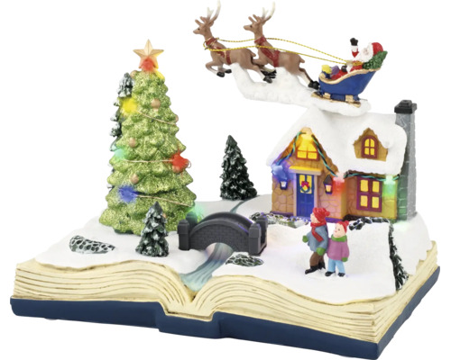 Kerstdecoratie in de vorm van een open boek met besneeuwd wintertafereel, verlicht huis, kerstboom en de Kerstman in een slee.