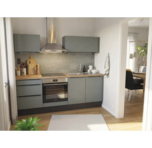Moderne kitchenette met grijze kasten, houten aanrechtblad, inbouwoven, kookplaat, roestvrijstalen afzuigkap en grijze tegelwand.