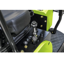 Detailweergave van de bedieningselementen van een bouwmachine met een hendel, een urenteller en een zitting.