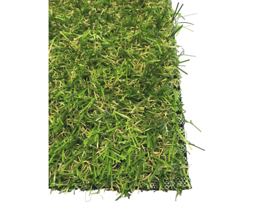 Kunstgras van groene en beige synthetische sprieten in detailopname.