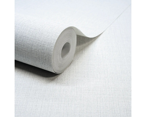 Lichtgrijs vliesbehang met een fijne linnenstructuur, een gedeeltelijk afgerolde rol behang.