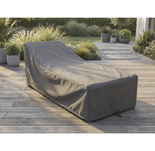 Grijze beschermhoes voor ligbed op een houten terras in een lichte, georganiseerde tuin.