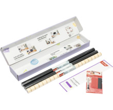d-c-fix designfolie set in een geopende verpakking met zwarte rollen, een rol met patroon, vouwsjabloon en applicatieset.