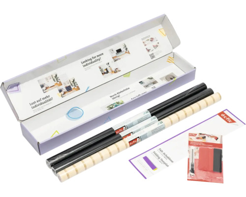 d-c-fix designfolie set in een geopende verpakking met zwarte rollen, een rol met patroon, vouwsjabloon en applicatieset.
