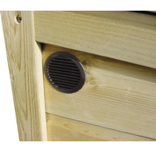 Rond ventilatierooster ingebouwd in een wand van houten planken.