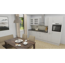 Moderne witte inbouwkeuken met inbouwapparatuur en eethoek met houten tafel en beklede bank.