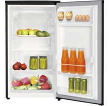 Open koelkast met wit interieur, gevuld met vers fruit, groenten en dranken op schappen en in deurvakken.
