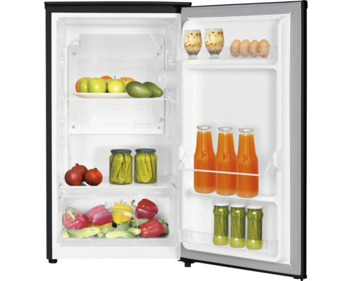Open koelkast met wit interieur, gevuld met vers fruit, groenten en dranken op schappen en in deurvakken.