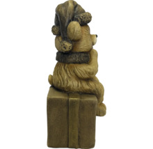 Kerstfiguur beer met muts en sjaal zittend op een cadeauverpakking.