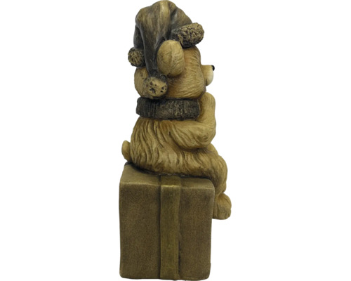 Kerstfiguur beer met muts en sjaal zittend op een cadeauverpakking.