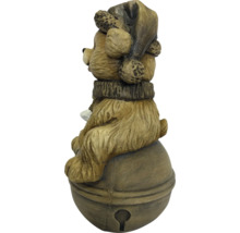 Kerstfiguur beer met muts en sjaal zittend op een bel