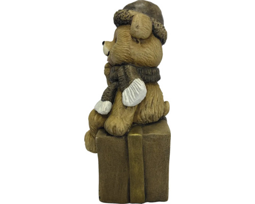 Decoratiefiguur beer zittend op een geschenkdoos met wintermuts en sjaal.