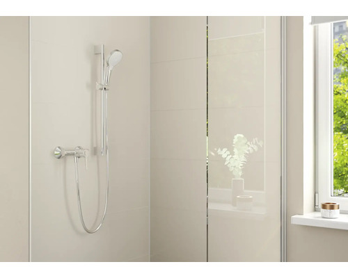 Moderne doucheset met handdouche, douchestang en eenhendelmengkraan in een lichte badkamer met tegels en glazen wand.