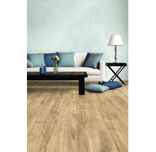 Moderne woonkamer met lichte vloer in houtlook, witte bank met blauwe kussens en een zwarte salontafel.