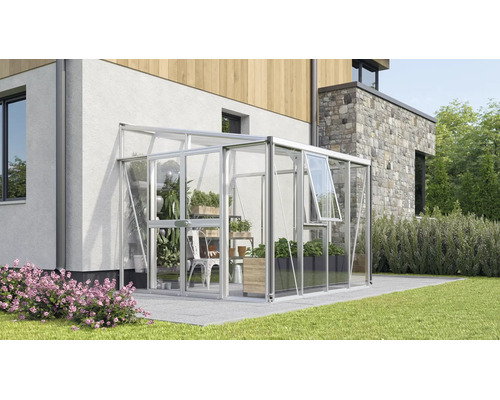 Moderne muurkas van aluminium en glas, bevestigd aan een huis op een terras met planten binnenin.