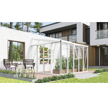 Witte aanleunkas van aluminium en glas tegen een witte bakstenen muur op een modern terras met planten en tuinmeubelen.