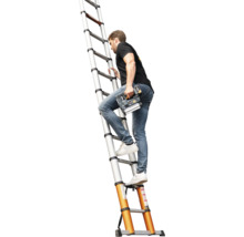 Een persoon klimt op een zilveren aluminium telescopische ladder met oranje voeten en houdt een accutacker vast.