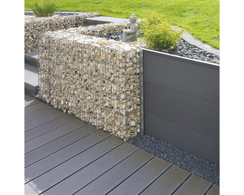 Moderne tuinarchitectuur met een schanskorf gevuld met natuursteen, een tuinscherm en vlonderplanken.