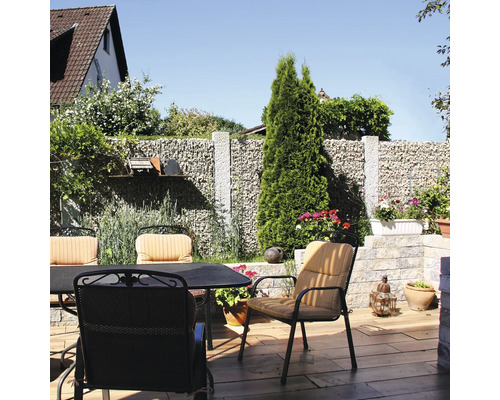 Zitset op een terras met een schanskorfmuur, tuinstoelen met kussens en een tuintafel op een vloer met houtlook.