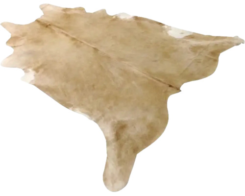 Koeienhuid vloerkleed van echt bont in beige met natuurlijke vorm.