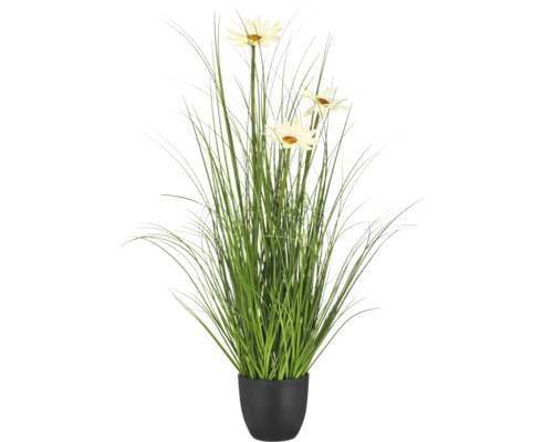 Kunstgrasplant met witte bloemen in zwarte pot.