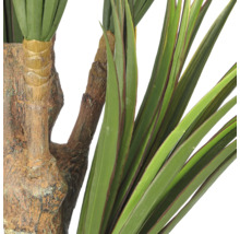 Detailopname van een kunstmatige Yucca plant met een getextureerde stam en lange, puntige bladeren.