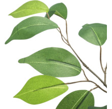 Detail van een kunstplanttak met groene, ovale bladeren aan een bruine stengel.