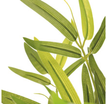 Detailopname van de smalle, groene bladeren van een kunstbamboeplant.