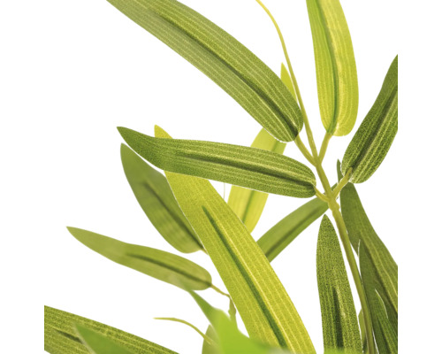 Detailopname van de smalle, groene bladeren van een kunstbamboeplant.
