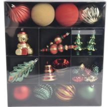 Set met rode, gouden en groene kerstballen en kersthangers zoals een beer, kerstboom, blad en bel in een doos.