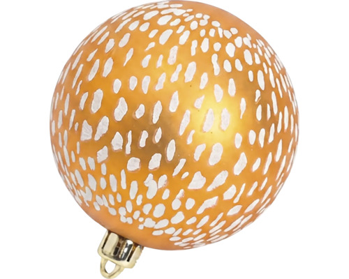 Glazen kerstbal met wit stippenpatroon op een oranje ondergrond.