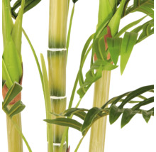 Close-up van een kunstplant met dikke stengels en groene bladeren. De stengels hebben gesegmenteerde knopen die lijken op bamboe.